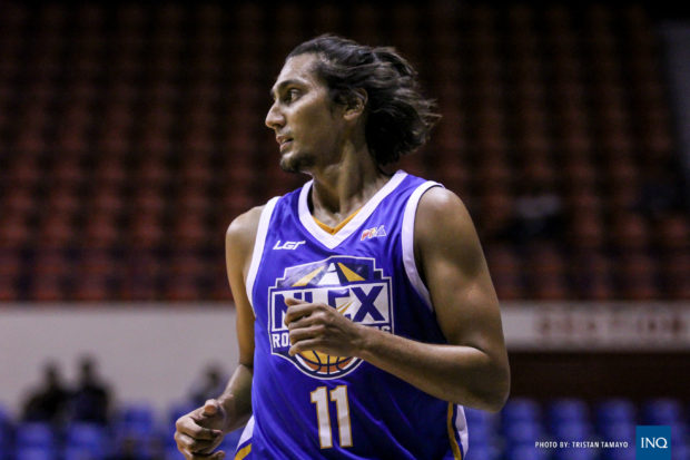 Alex Mallari playing basketball with determination and focus.